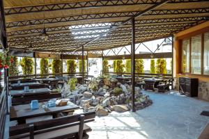a patio with wooden tables and benches and rocks at Sonyachniy Promin in Polyana