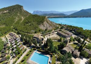 z góry widok na ośrodek z basenem i jeziorem w obiekcie Casa Forestal w mieście Aínsa