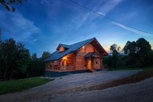 a log cabin with a light on at WOODS LODGE PLITVICE LAKES in Drežnik Grad