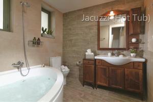 a bathroom with a tub and a sink and a toilet at Chandax luxury villa in Heraklio Town +35 photos