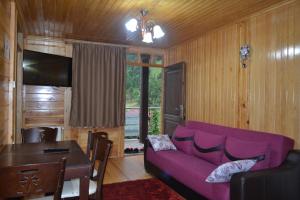 a living room with a purple couch and a table at Ozturk Apart in Uzungöl