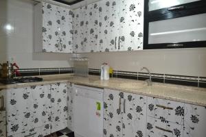 a kitchen with white cabinets and black and white wallpaper at Ozturk Apart in Uzungöl