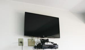 a flat screen tv hanging on a wall at Pousada Mello in Arroio do Silva