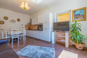 a kitchen and a living room with a couch and a table at Villa M in Crikvenica