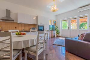 a kitchen and living room with a white table and chairs at Villa M in Crikvenica