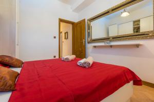 a bedroom with a red bed with a mirror at Villa M in Crikvenica
