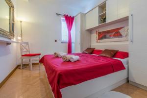 a bedroom with a red bed with a red blanket at Villa M in Crikvenica