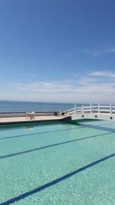 a bridge over a swimming pool with a horse on it at Ocean front apartment. in San Antonio del Mar