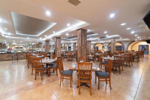 un restaurante con mesas y sillas de madera y un bar en Hotel Malibu, en Guadalajara