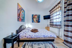 a bedroom with a bed and a desk and a window at Villa Ruža Apartments in Zlatibor