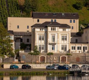 a large white building with cars parked in front of it at Ferienhaus Mosel-Herberge in Bernkastel-Kues