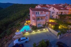 a house with a car parked in front of a pool at Villa M in Crikvenica