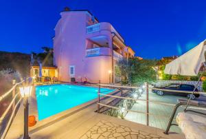 a villa with a swimming pool at night at Villa M in Crikvenica