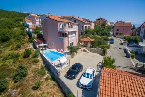 two cars parked in a parking lot next to a house at Villa M in Crikvenica