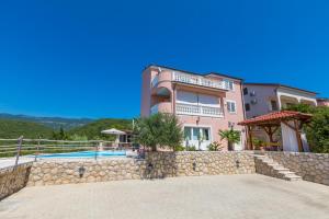 a large pink house with a stone wall at Villa M in Crikvenica