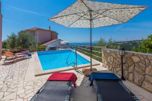 a villa with a swimming pool and an umbrella at Villa M in Crikvenica