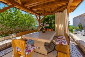a table and chairs under a wooden pergola at Villa M in Crikvenica