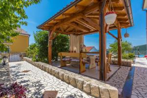 a wooden pergola with a table in a yard at Villa M in Crikvenica