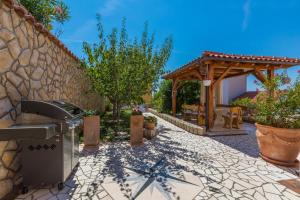a stone walkway with a outdoor grill and a stone wall at Villa M in Crikvenica