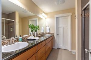 a bathroom with two sinks and a large mirror at Modern home, Four bedrooms, King Beds in Tigard