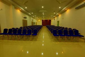 an empty room with blue chairs in a hall at Sara Hotels and Apartments in Nedumbassery