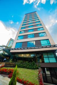 a tall building with a garden in front of it at Café Hotel Medellín in Medellín