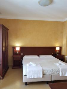 カステルブオーノにあるHotel Paradiso Delle Madonieのベッドルーム1室(ベッド2台、ナイトスタンド2台付)