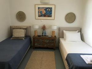 ein Zimmer mit 2 Betten und einem Tisch mit einem Nachttisch in der Unterkunft The Hill Top House in Kea in Ioulis