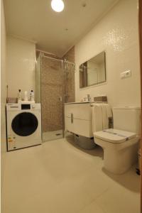 a bathroom with a toilet and a sink and a shower at Apartamentos Playa Compostela in Vilagarcia de Arousa