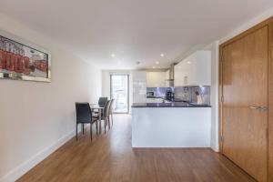 a kitchen and dining room with a white counter top at Bright and Modern 3 Bed Apartment Hyde Park Central London in London
