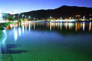 uma grande massa de água à noite com luzes em Pousada da Lagoa em Florianópolis
