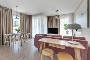 sala de estar con sofá y mesa en Wave Apartments - Olivia Park, en Gdansk