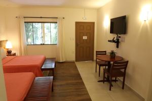 a room with a bed and a table and a television at Amazon Ecopark Jungle Lodge in Manaus