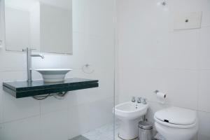 Un baño blanco con inodoro y lavabo. en Tucuman Palace Hotel, en Buenos Aires