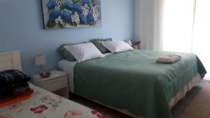 a bedroom with a bed with a green bedspread at Residência Familiar in Campinas