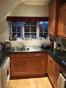 a kitchen with wooden cabinets and a sink at Paul’s Place, 5 minutes from the beach in Bournemouth