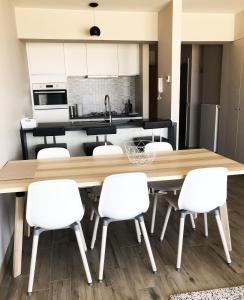 a kitchen with a large wooden table and white chairs at Appartement verhuur Zeedijk Middelkerke Sunbeach in Middelkerke