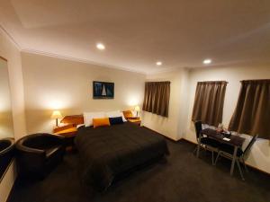 a hotel room with a bed and a desk at Fitzherbert Castle Motel in Palmerston North