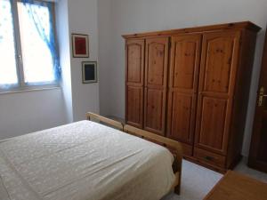 - une chambre avec un lit et une grande armoire en bois dans l'établissement Casa vacanza a due passi dal mare, à Alghero