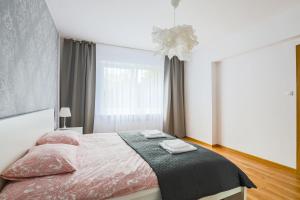 a bedroom with a bed with two towels on it at Apartament Pod Winogronami in Kraków