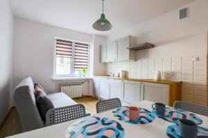 ein Wohnzimmer mit einem Tisch und einer Küche in der Unterkunft Apartament Pod Winogronami in Krakau