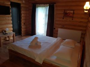 - une chambre avec un lit et 2 serviettes dans l'établissement Casa Pădurarului, à Prisaca Dornei
