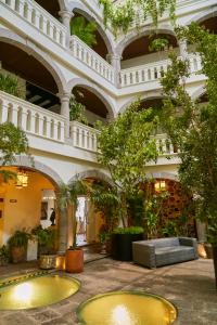 un hall avec des arbres et un canapé dans un bâtiment dans l'établissement Casona de los Sapos Hotel Boutique, à Puebla
