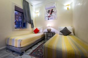 1 dormitorio con 2 camas y ventana en Riad Belko en Marrakech