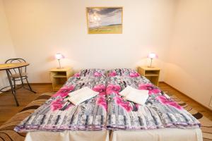 ein großes Bett in einem Zimmer mit 2 Tischen in der Unterkunft Ubytovanie Marta Vavreková in Habovka
