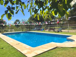 een zwembad met blauw water in een tuin bij Casa da Quinta da Prelada Simão in Celorico de Basto