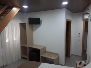 a room with a bed and a tv on a wall at Fonte d' Amandos in Arganil