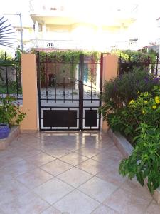 una puerta abierta a un patio con flores y plantas en Socrates Apartments, en Olympiakí Aktí