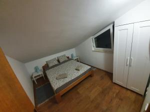 a small bedroom with a bed and a tv at Allure Apartment in Kornić