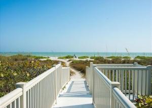 Una pasarela a una playa con el océano en el fondo en Sandpiper Beach #405, en Sanibel